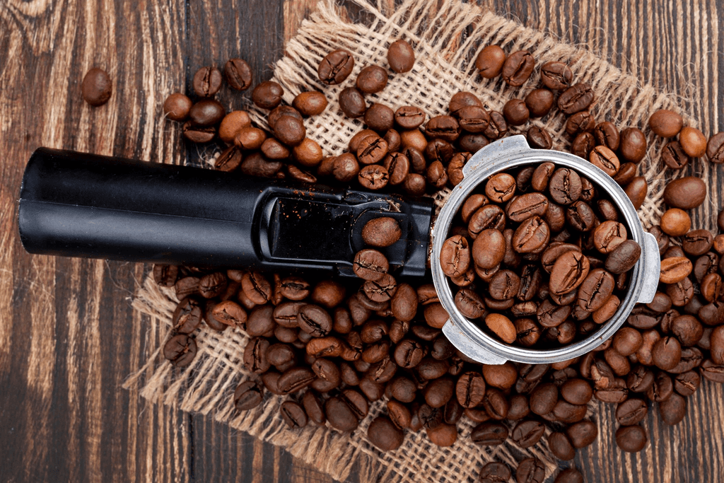 Coffee grinder with coffee beans on a wooden surface