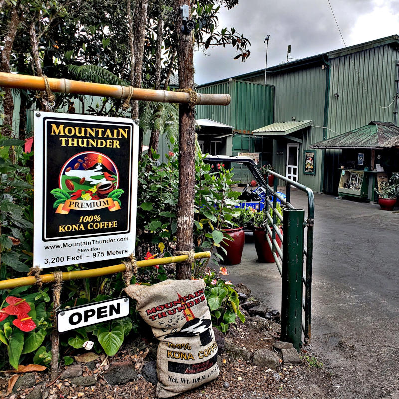 entrance of mountain thunder coffee plantation with 100lb sack full of coffee